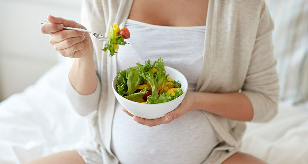 A person is eating a salad from a bowl.