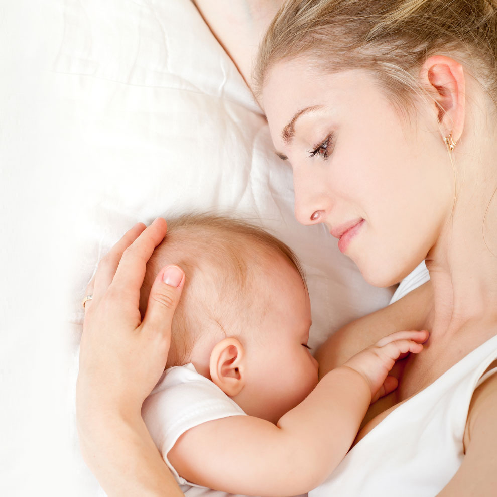 A woman lovingly holds a baby close to her.