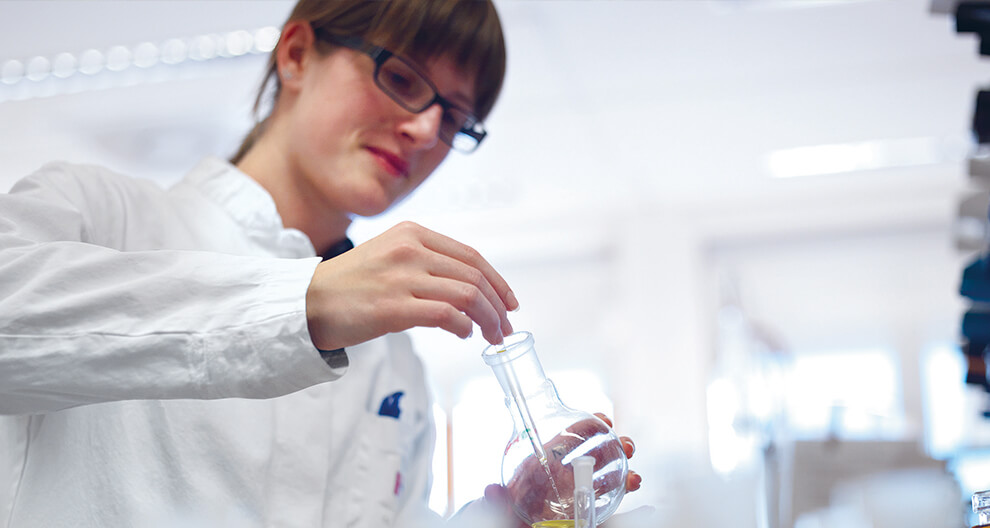 A person in a white lab coat is conducting an experiment in a laboratory.